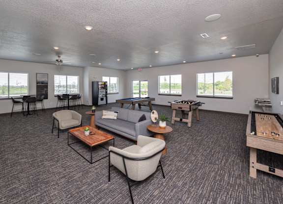 A spacious living room with grey carpeting and furniture.