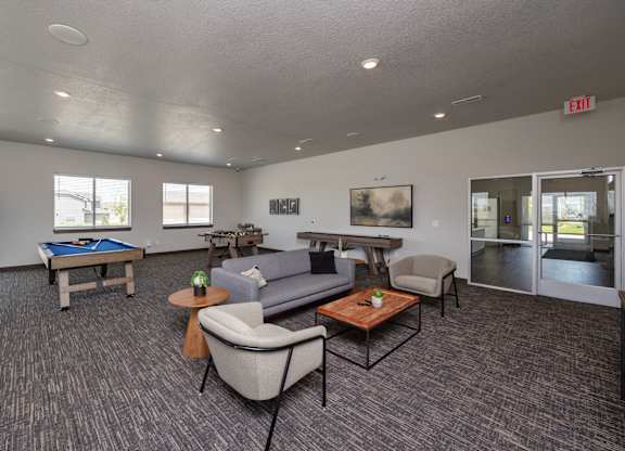 A spacious room with a pool table, couches, and a painting.