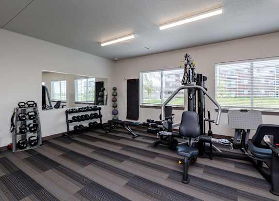 A well-equipped gym with a variety of exercise machines and weights.