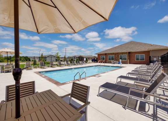 A pool area with sun loungers and a table.