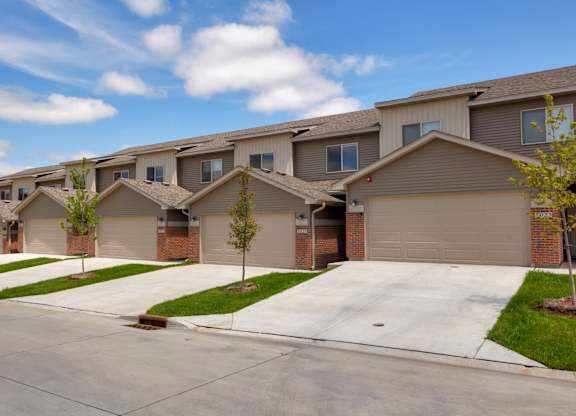 A row of houses with garages and driveways.