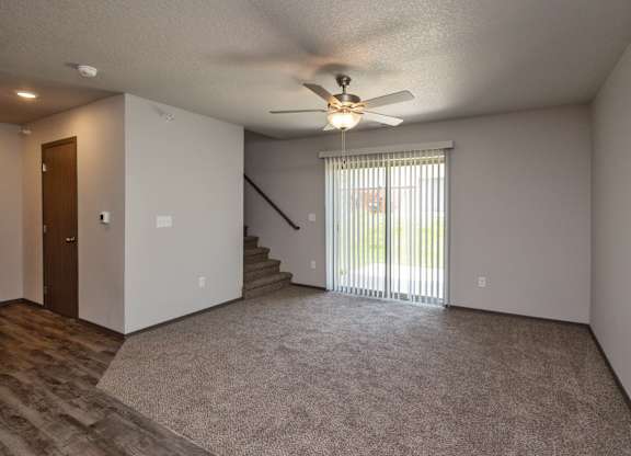 A room with a ceiling fan and a carpeted floor.
