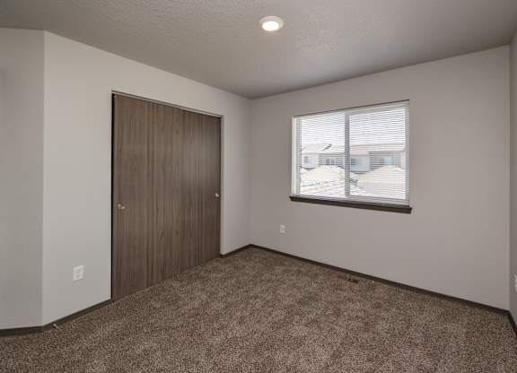 A room with a brown carpet and a brown door.