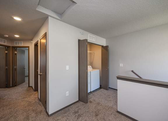 A room with a white wall and a brown carpet.