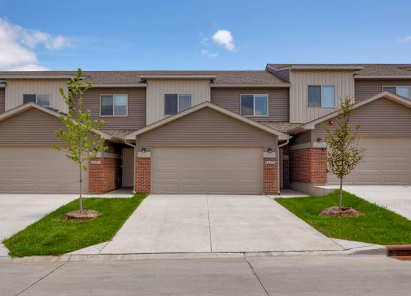 A row of houses with garages and driveways.
