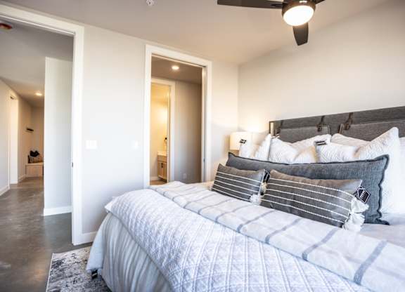 A bedroom with a large bed and a ceiling fan.