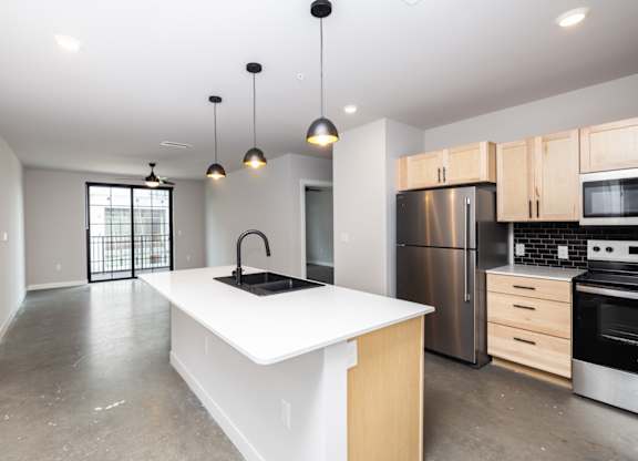 A modern kitchen with a white island and stainless steel appliances.