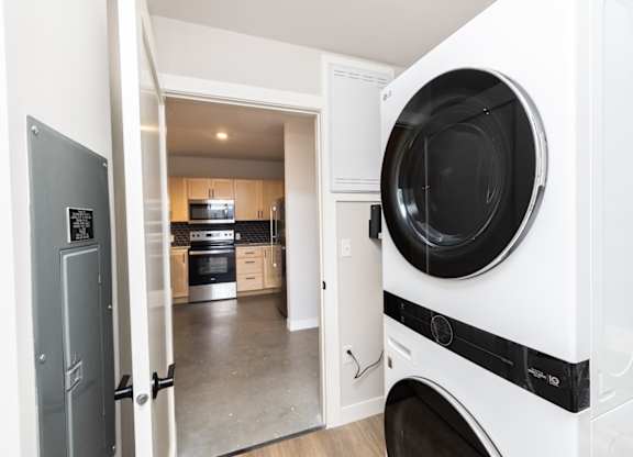 A white washing machine is in a kitchen.