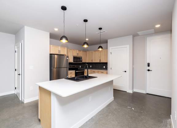 A kitchen with a white island and wooden cabinets.