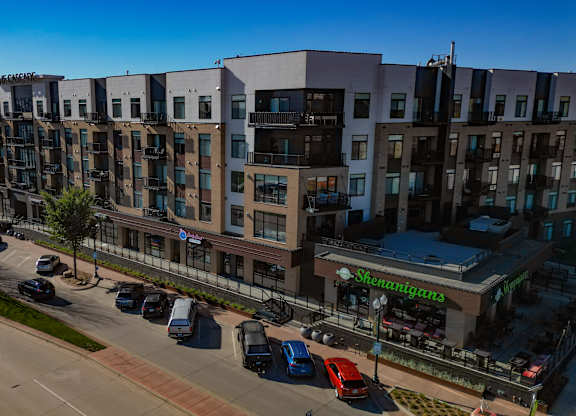 A street view of a residential area with cars parked on the side of the road.
