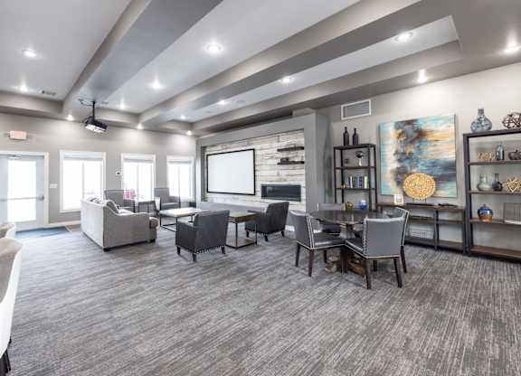 A spacious room with grey carpeting and furniture.