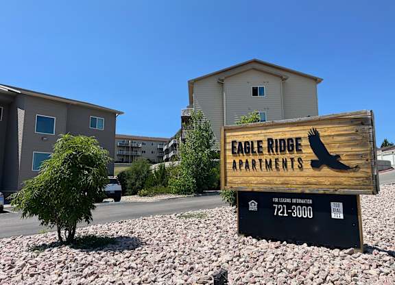 A sign for Eagle Ridge Apartments is in front of a building.