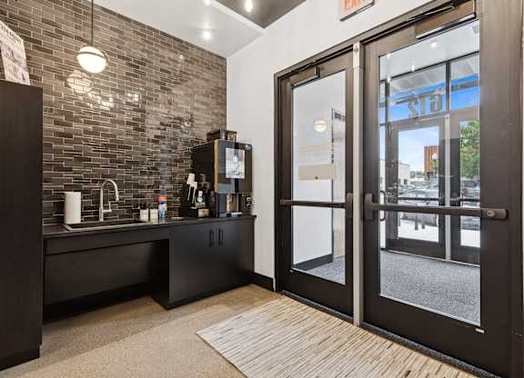 A black and white kitchen with a glass door entrance.