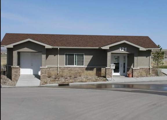 A house numbered 121 with a brown roof and a white door.