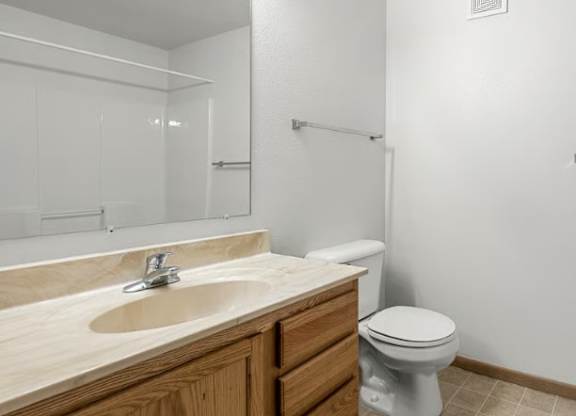 A bathroom with a toilet, sink, and shower.
