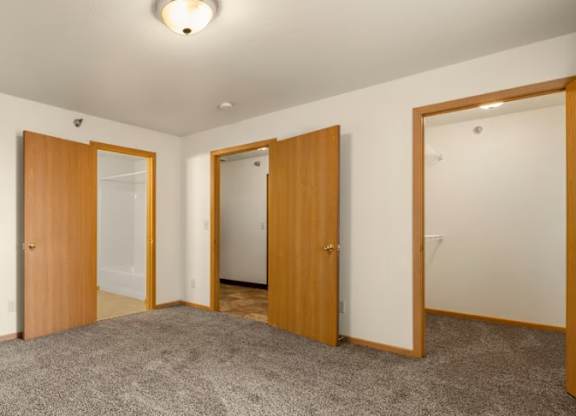 Three doors are in a room with carpeting.
