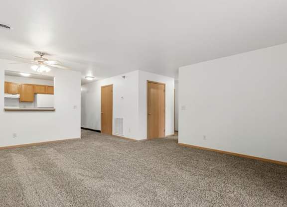 A room with a carpeted floor and two doors.