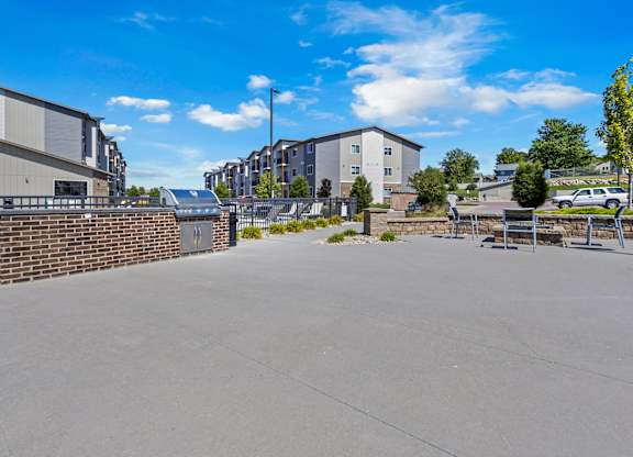 A parking lot with a building and a wall in the background.