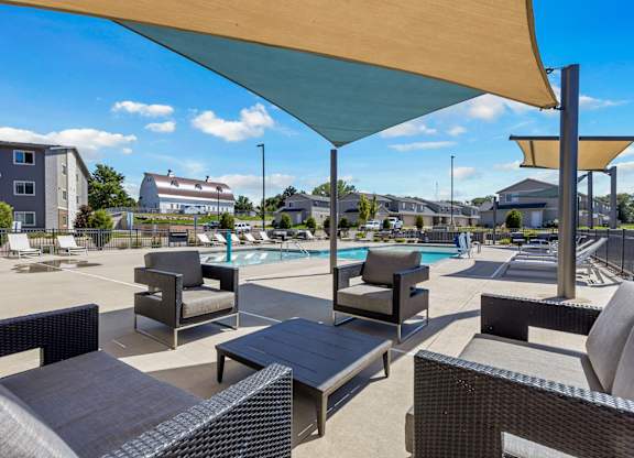 A sunny day at the poolside with lounge chairs and umbrellas.