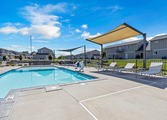 A large outdoor swimming pool with a sunshade.