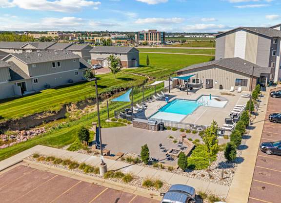 A large building complex with a pool and parking lot.