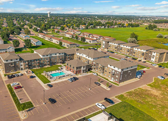 A large parking lot is surrounded by apartment buildings.