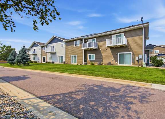Apartment building with a green lawn in front.