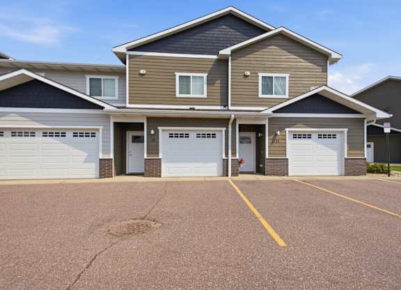 A row of houses with garages and driveways.