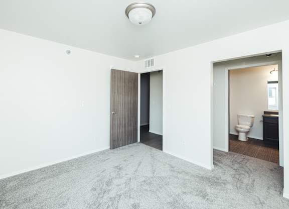 an empty room with a toilet and a door to a bathroom