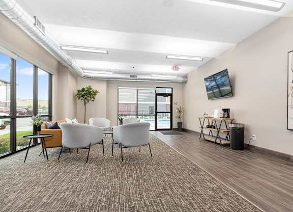 A room with white chairs and a brown carpet.
