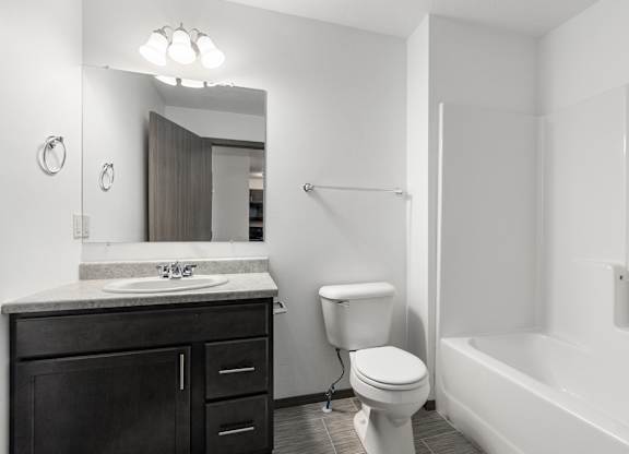 A white bathroom with a toilet, sink, and bathtub.