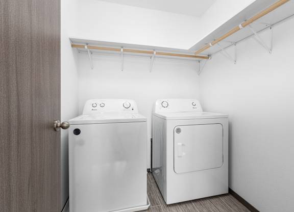 Two white washing machines in a laundry room.