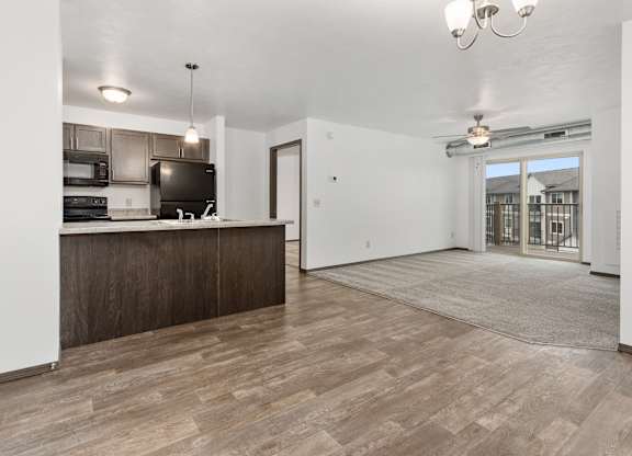 A kitchen with a wooden floor and a white wall.