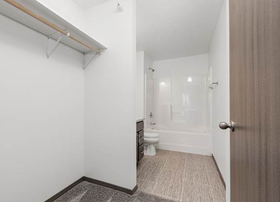 A white bathroom with a toilet, sink, and mirror.