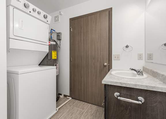 A small bathroom with a washer and dryer built into the cabinetry.