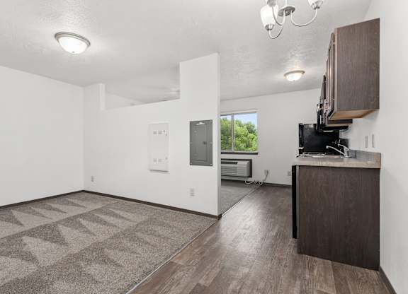 A spacious room with a patterned carpet and a wooden cabinet.