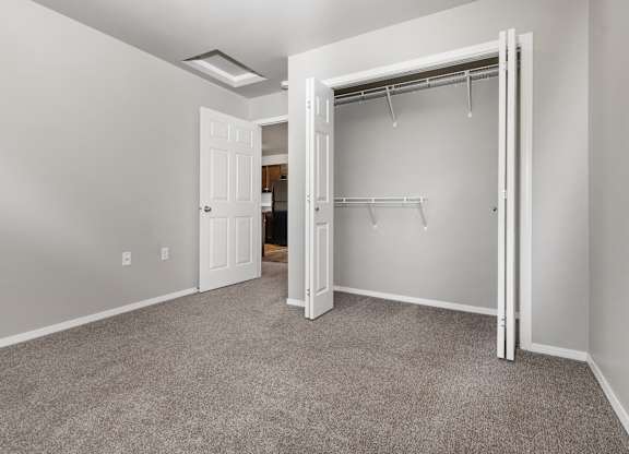 A room with a carpeted floor and a white door.
