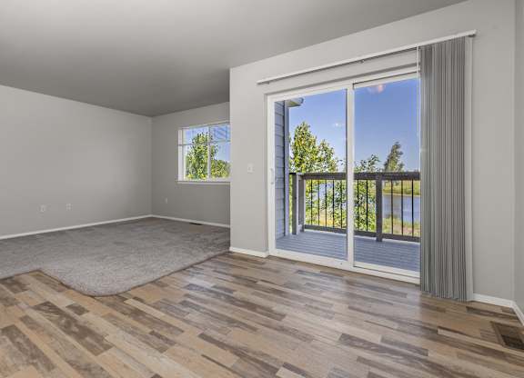 A room with a sliding glass door leading to a balcony.