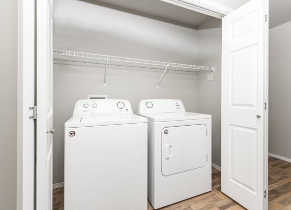 Two white washing machines in a laundry room.