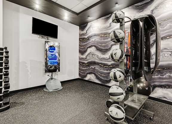 A room with a white wall and a black television on the wall.
