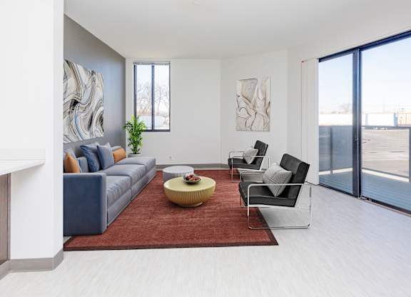 A living room with a grey couch, a yellow coffee table, and a painting on the wall.