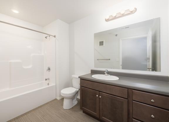 A white bathroom with a toilet, sink, and bathtub.