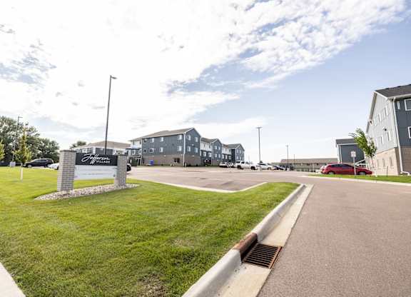A sign in front of a building with a grassy area in front of it.