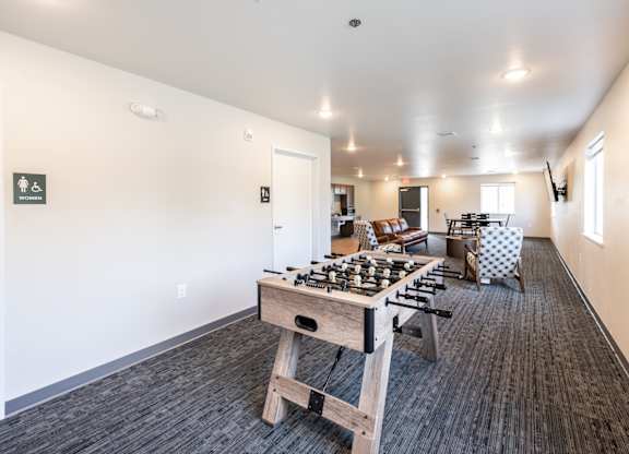 A room with a wooden table and chairs and a carpeted floor.