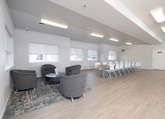 A room with grey chairs and a long table.