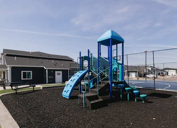 A playground with a blue slide and tower.