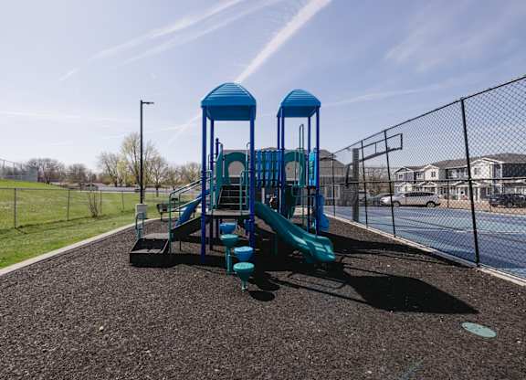 A playground with a blue slide and two blue towers.