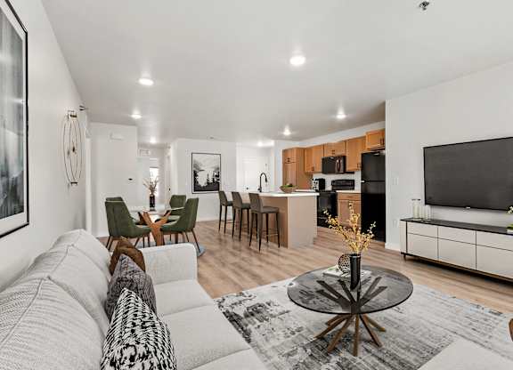 A modern living room with a grey sofa and a black and white patterned throw pillow.