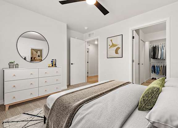 A bedroom with a bed, dresser, and mirror.