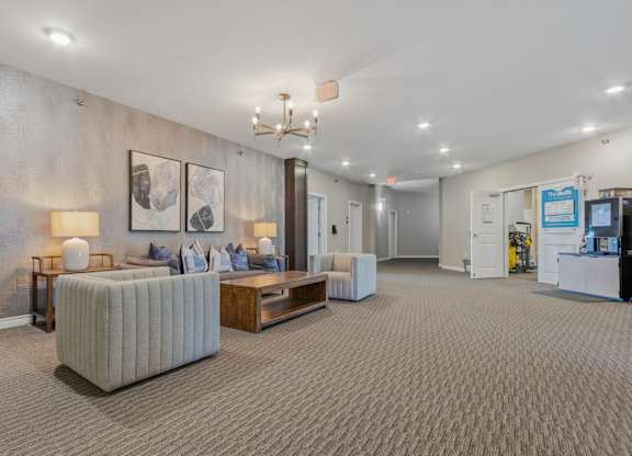 A well-lit waiting room with a grey sofa and a wooden coffee table.